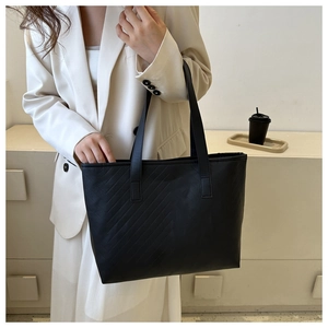 Close-up of black tote bag with chevron quilting and elegant flat handles for office