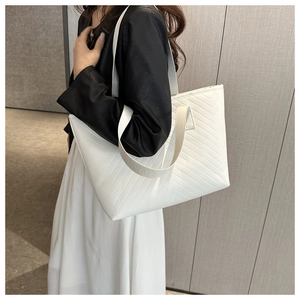 Detail of white quilted tote bag with V-shaped stitching and double shoulder straps