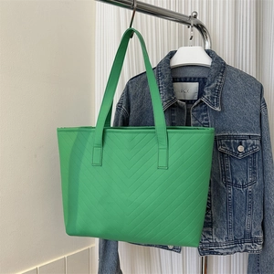 Detail of green tote bag with V-shaped quilting and matching long shoulder strap