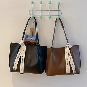Minimalist large leather tote bag in black and brown with stylish ribbon detail