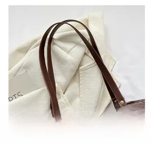 Close-up of brown quilted tote bag showing fine leather texture and metal ring connection