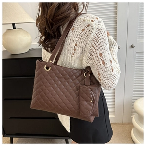 Detail of dark brown quilted tote bag with matching coin purse and golden metal rings