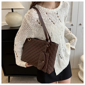 Detailed view of quilted dark brown tote bag with matching mini coin purse attachment