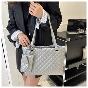 Detailed view of grey quilted tote bag set with matching pouch and silver metal hardware