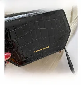 Close-up of black crocodile pattern faux leather with golden fashion text branding