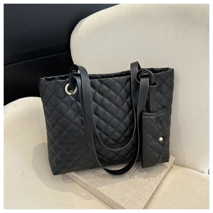 Detail of black quilted tote bag with matching pouch and golden eyelet accents