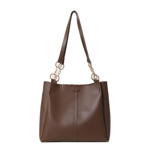 Minimalist dark brown tote bag with gold chain straps and vertical stitching detail