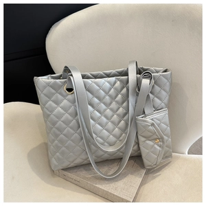 Detail of silver quilted tote bag with matching coin purse and metallic finish texture