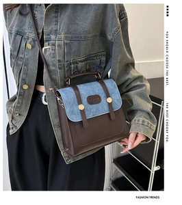 Detail of vintage bucket bag featuring blue denim and brown leather patchwork design