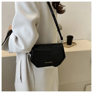 Detail of black faux crocodile patent leather bag with gold Fashion & Bags lettering