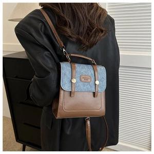 Vue arrière du modèle portant un sac à dos rétro en similicuir marron et denim bleu