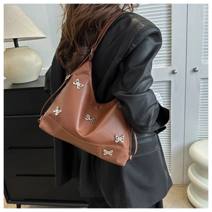 Vue détaillée du sac hobo en cuir PU marron avec des breloques papillon argentées