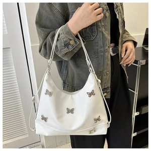 Detail der weißen PU-Leder Tote Tasche mit silbernen Schmetterlingen und langem Schultergurt