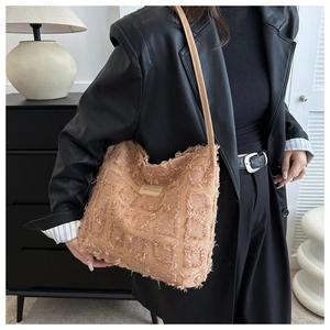 Détail de la texture effilochée et étiquette sur le sac seau marron à franges