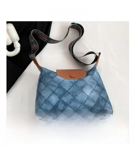 Detail der gesteppten Canvas-Tasche mit Lederklappe und Ethno-Muster-Gurt