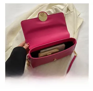 Interior storage view of rose red crossbody bag with wallet and electronic items