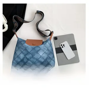 Draufsicht einer blauen geometrischen Tragetasche mit brauner Lederklappe und Retrogurt