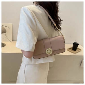 Side view of a lavender square flap bag with a gold buckle worn as a shoulder bag