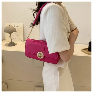 Detail of rose red leather baguette bag with golden hollow buckle and chain strap