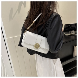 Detailed view of a white baguette bag featuring a gold metal lock and chain strap