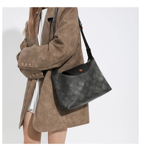 Model trägt dunkelgraue große Shopper-Tasche mit Steppmuster und bedrucktem Gurt