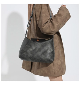 Detail der grauen Web-Tasche mit Lederklappe und geometrisch gemustertem Riemen