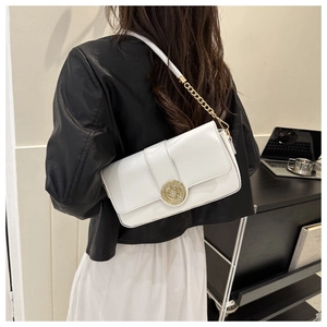 Detail showing white flap crossbody bag with golden sunflower buckle and chain strap