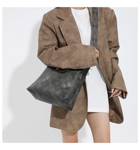 Detailaufnahme der schwarzen Stepptasche mit buntem Schultergurt im Ethno-Stickerei-Stil
