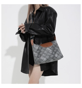 Detailansicht der Denim-Tasche mit gemustertem Gurt am Model mit Lederjacke