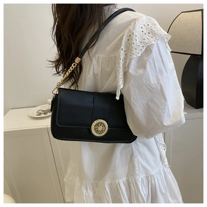 Detail of elegant black leather bag with a luxury gold rhinestone buckle and chain strap