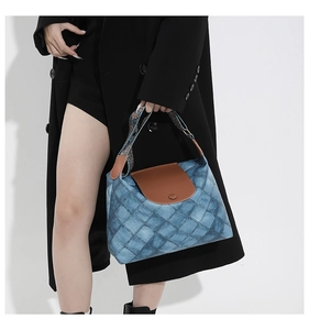 Details der blauen Denim-Patchwork-Tasche mit Lederklappe und Retro-Web-Schultergurt