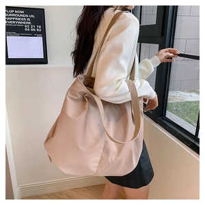 Detailed side view of the large capacity canvas tote bag with wide strap on a model