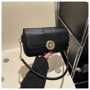 Detail of black leather flap bag featuring a vintage round gold buckle and chain strap