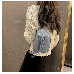 Dettaglio della borsa a tracolla in pelle grigia con stile back-wear e zip argento