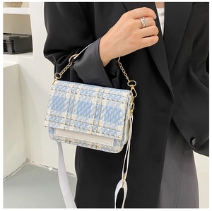 Detailansicht der blau-weißen Tweed-Struktur und Goldkette der Umhängetasche