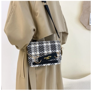 Detail der Tweed-Karo-Tasche mit goldener Kette und metallischen Rundakzenten