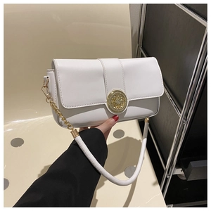 Detail of white leather shoulder bag featuring a decorative gold filigree buckle and chain