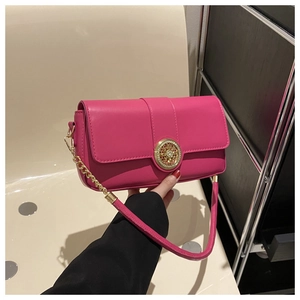 Detail of rose red leather bag with ornate gold buckle and sparkling rhinestone trim