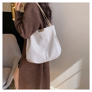 White large capacity canvas tote bag with brown leather accent on a female model