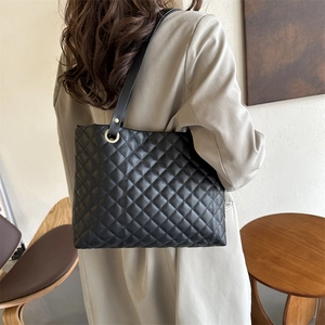 Chic black quilted tote bag with golden hardware shown in a stylish lifestyle setting