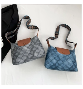 Detail von blau und grau gesteppten Taschen mit Vintage-Musterträgern auf weißem Grund