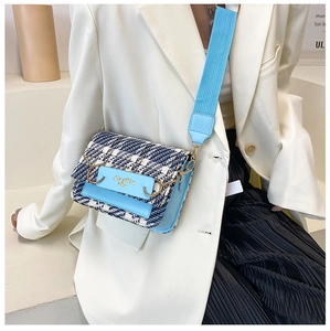 Detail der blau-karierten Tweed-Umhängetasche mit breitem Gurt und goldener Metallschnalle