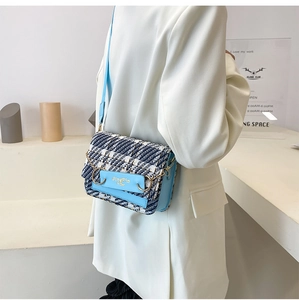 Detail der blau karierten Tweed-Umhängetasche mit Goldverschluss und Leder-Schultergurt