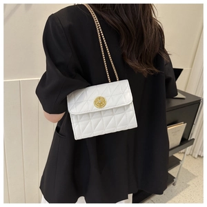 Détail du sac bandoulière blanc matelassé avec boucle dorée et cristaux brillants