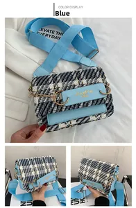 Detail der blau-karierten Tweed-Tasche mit goldenen Akzenten und gewebtem Schultergurt
