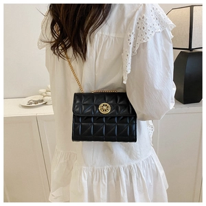 Détail du sac à bandoulière matelassé noir avec boucle gouvernail dorée et chaîne