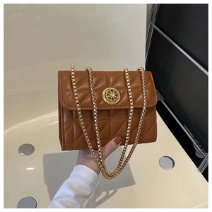 Détail d'un sac en cuir matelassé marron avec boucle dorée ronde et bandoulière