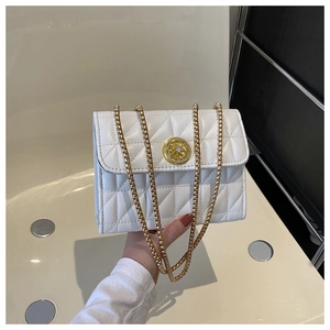 Détails de la texture matelassée blanche et fermoir doré sur un petit sac bandoulière