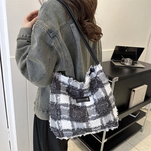 Sac fourre-tout à carreaux noir et blanc avec bords effilochés et logo en cuir