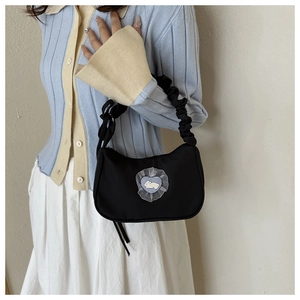 Sac croissant noir en nylon avec écusson lapin et anse froncée porté par un mannequin